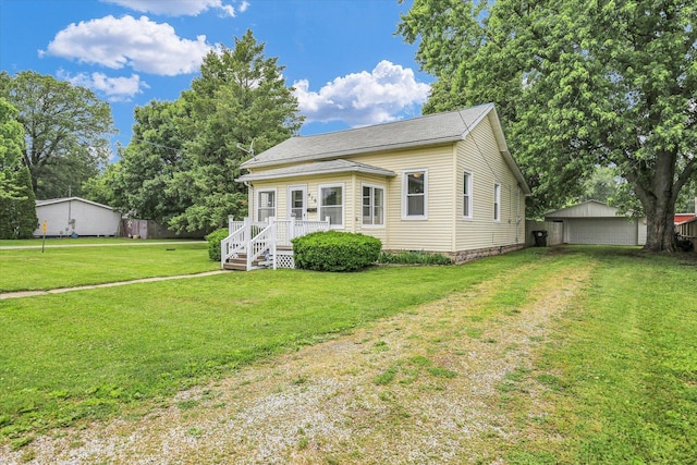 416 W Wing St, Bement, IL 61813 - view of front of house with a front yard, an outdoor structure, a wooden deck, and a garage