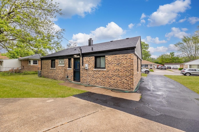 328 Nassau St, Park Forest, IL 60466 - rear view of house featuring brick siding, a yard, a chimney, and a shingled roof