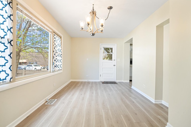 5701 N Mobile Ave, Chicago, IL 60646 - unfurnished dining area featuring a chandelier, light wood finished floors, and baseboards