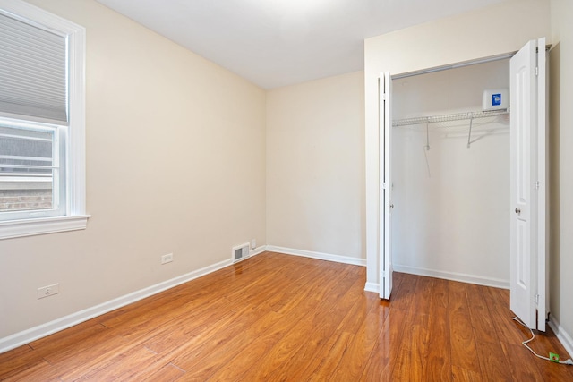 5701 N Mobile Ave, Chicago, IL 60646 - unfurnished bedroom with light wood-type flooring, a closet, and baseboards