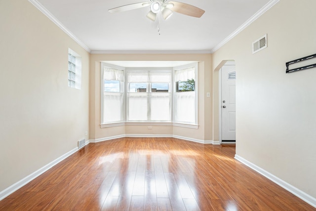 5701 N Mobile Ave, Chicago, IL 60646 - unfurnished room with ceiling fan, arched walkways, wood finished floors, crown molding, and baseboards