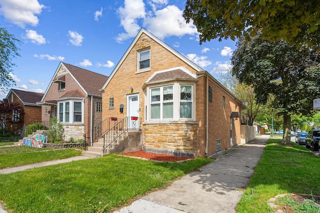 5701 N Mobile Ave, Chicago, IL 60646 - view of front facade with a front yard, stone siding, and brick siding