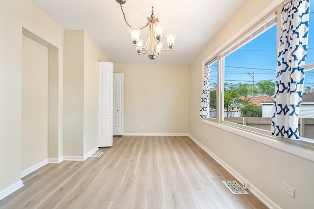 5701 N Mobile Ave, Chicago, IL 60646 - empty room featuring a chandelier, wood finished floors, and baseboards