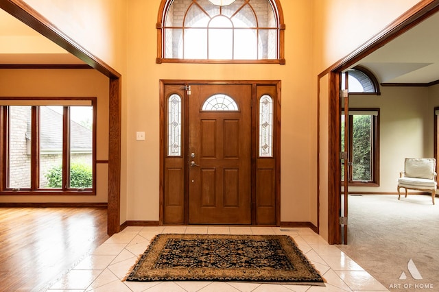 10801 Jillian Rd, Orland Park, IL 60467 - entryway with light tile patterned floors, baseboards, a towering ceiling, light carpet, and ornamental molding