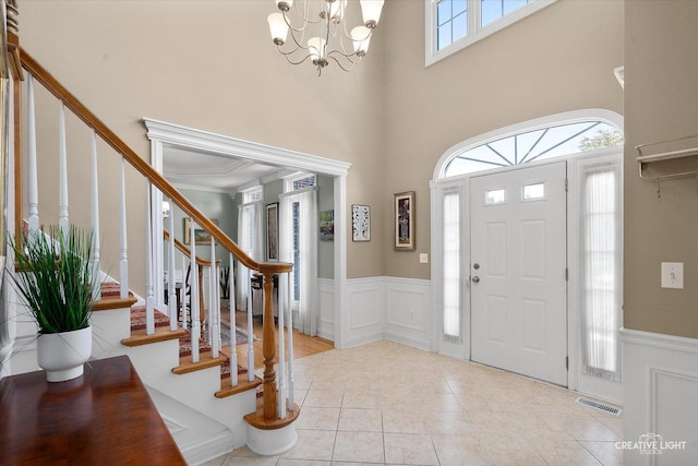 39W835 Carl Sandburg Rd, Saint Charles, IL 60175 - tiled entryway with wainscoting, stairway, a decorative wall, a chandelier, and a towering ceiling
