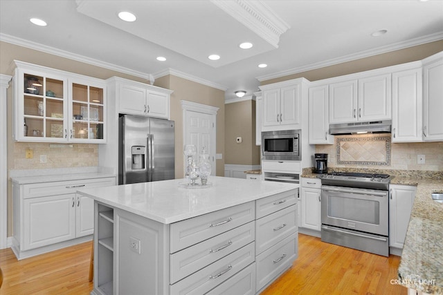 39W835 Carl Sandburg Rd, Saint Charles, IL 60175 - kitchen featuring stainless steel appliances, under cabinet range hood, white cabinets, light wood-style flooring, and ornamental molding