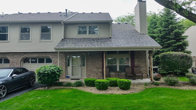 9352 Sunrise Ln Unit B1, Orland Park, IL 60462 - view of front of property featuring a porch, brick siding, a front lawn, a chimney, and an attached garage