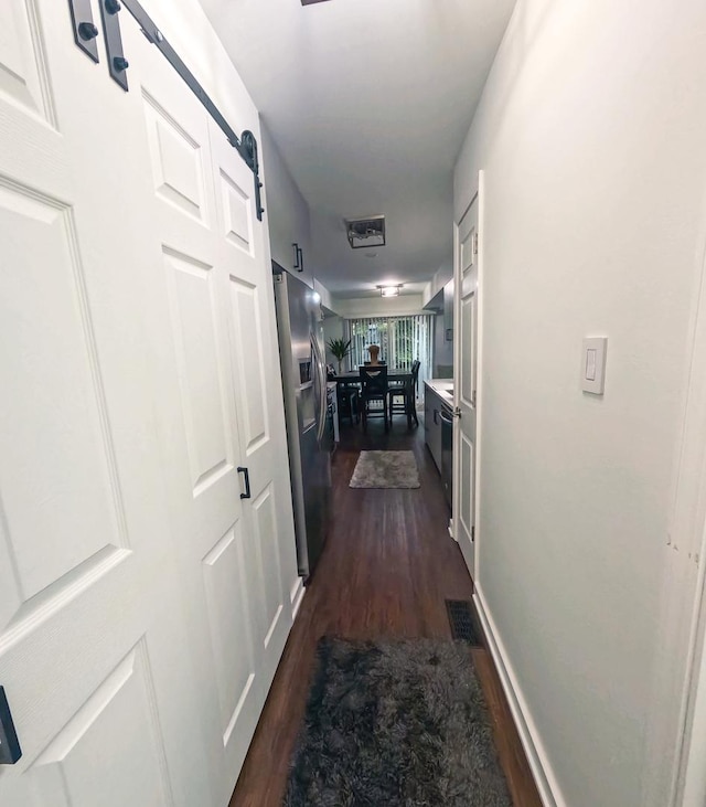 9352 Sunrise Ln Unit B1, Orland Park, IL 60462 - corridor with a barn door and dark wood-style flooring