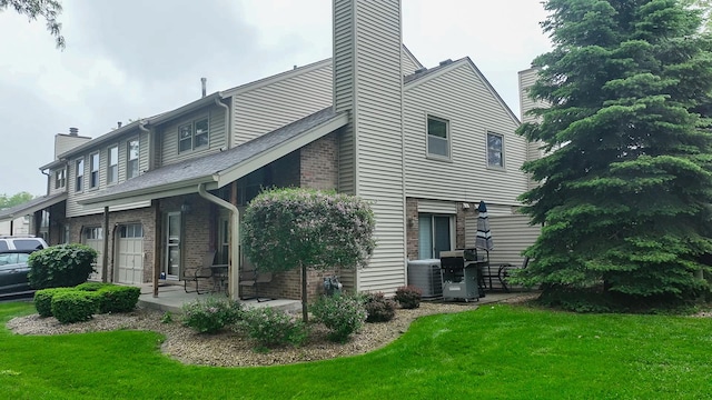 9352 Sunrise Ln Unit B1, Orland Park, IL 60462 - view of side of property with a chimney, central AC, a lawn, and brick siding