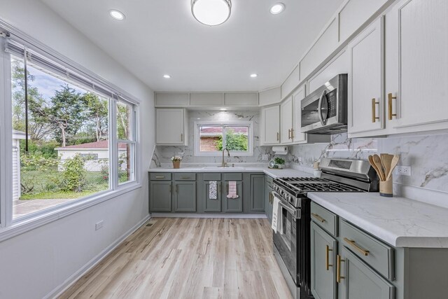 16228 Sussex Ave, Markham, IL 60428 - kitchen featuring appliances with stainless steel finishes, gray cabinetry, backsplash, light wood-style flooring, and recessed lighting