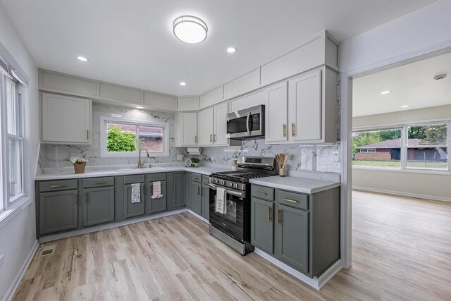16228 Sussex Ave, Markham, IL 60428 - kitchen with stainless steel appliances, gray cabinetry, decorative backsplash, light wood-style flooring, and recessed lighting