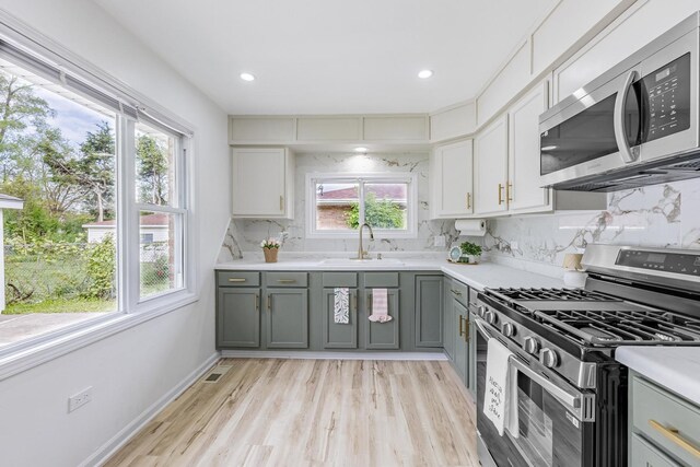 16228 Sussex Ave, Markham, IL 60428 - kitchen with stainless steel appliances, a sink, gray cabinets, tasteful backsplash, and light countertops