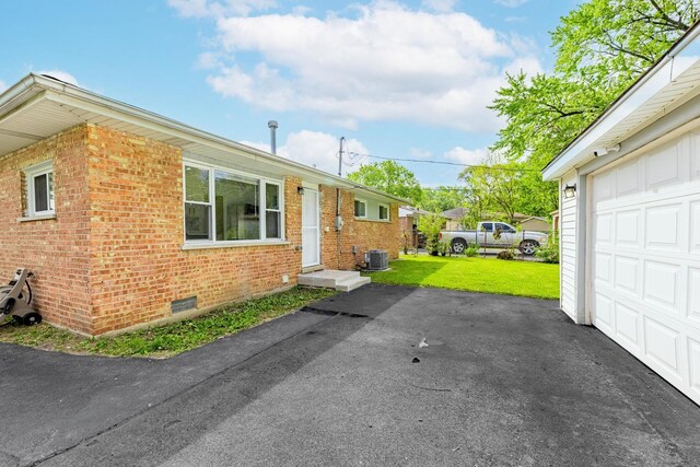 16228 Sussex Ave, Markham, IL 60428 - view of property exterior featuring brick siding, a lawn, cooling unit, a garage, and crawl space