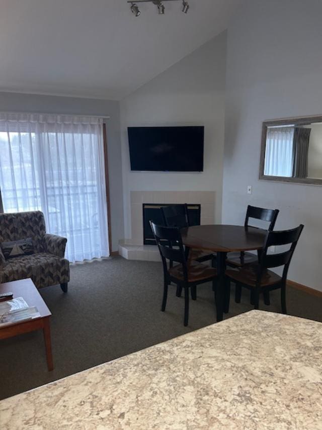 111 Center St Unit 441, Lake Geneva, WI 53147 - dining space with vaulted ceiling, a tile fireplace, plenty of natural light, carpet flooring, and rail lighting