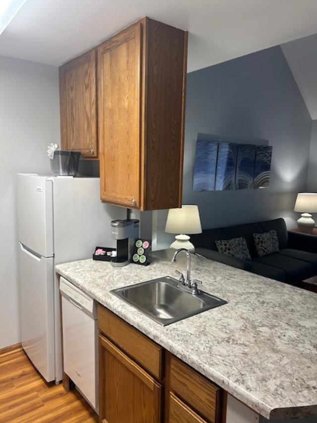 111 Center St Unit 441, Lake Geneva, WI 53147 - kitchen featuring white appliances, a sink, light wood-style floors, light countertops, and open floor plan