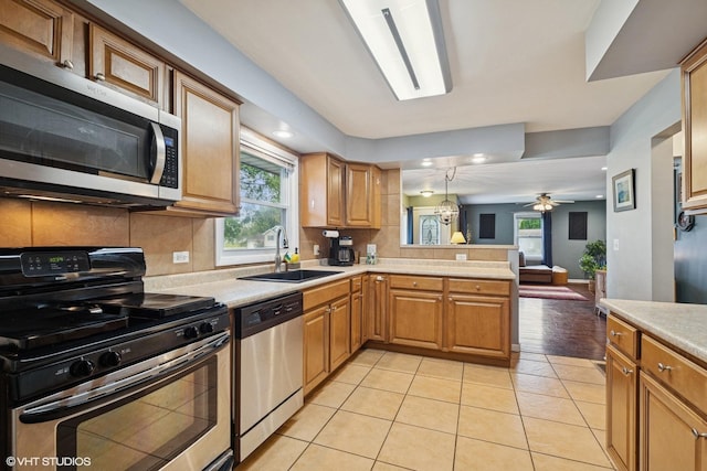 1511 Lakeland Ave, Mchenry, IL 60050 - kitchen with appliances with stainless steel finishes, a sink, light countertops, a peninsula, and light tile patterned floors