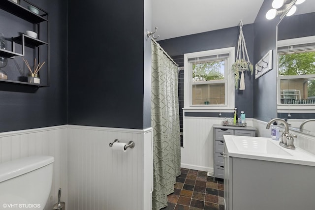 1511 Lakeland Ave, Mchenry, IL 60050 - bathroom with a wainscoted wall, stone tile flooring, vanity, and toilet