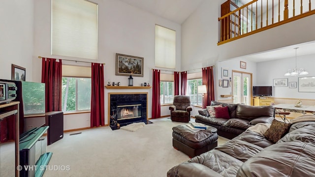 1031 S Wellington Rd, Waukegan, IL 60085 - carpeted living area featuring high vaulted ceiling, a chandelier, a tiled fireplace, and baseboards