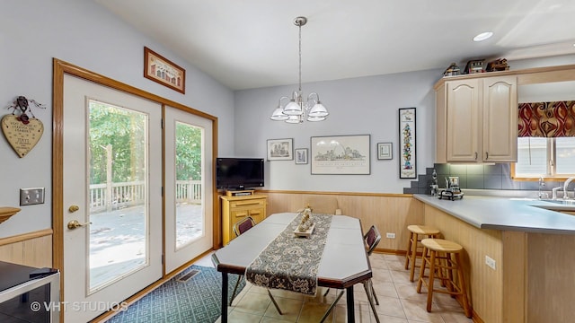 1031 S Wellington Rd, Waukegan, IL 60085 - dining area with light tile patterned floors, a chandelier, and a wainscoted wall