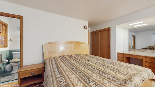 7421 N Crossway Rd, Fox Point, WI 53217 - bedroom with a closet, ensuite bathroom, and wood finished floors