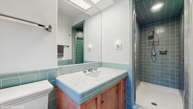 7421 N Crossway Rd, Fox Point, WI 53217 - bathroom with tile walls, a stall shower, vanity, and toilet