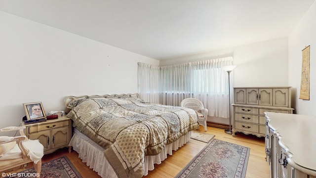 7421 N Crossway Rd, Fox Point, WI 53217 - bedroom featuring light wood-style flooring and a baseboard radiator