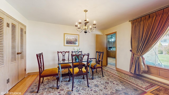 7421 N Crossway Rd, Fox Point, WI 53217 - dining area featuring a chandelier, light wood-style flooring, and baseboards
