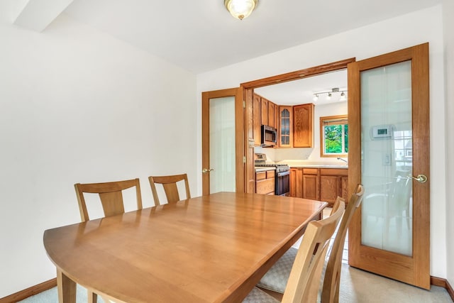 1328 Sunrise Ln, Gurnee, IL 60031 - dining room featuring french doors, baseboards, light carpet, and rail lighting