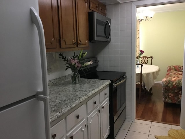 200 Deborah Ln NW Unit 16A, Wheeling, IL 60090 - kitchen featuring stainless steel appliances, light tile patterned floors, and light stone countertops