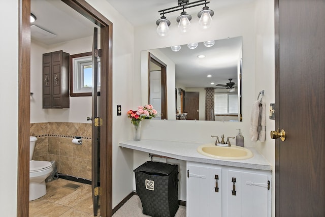1083 Groton Ct, Schaumburg, IL 60193 - bathroom with tile walls, toilet, ceiling fan, vanity, and a wainscoted wall