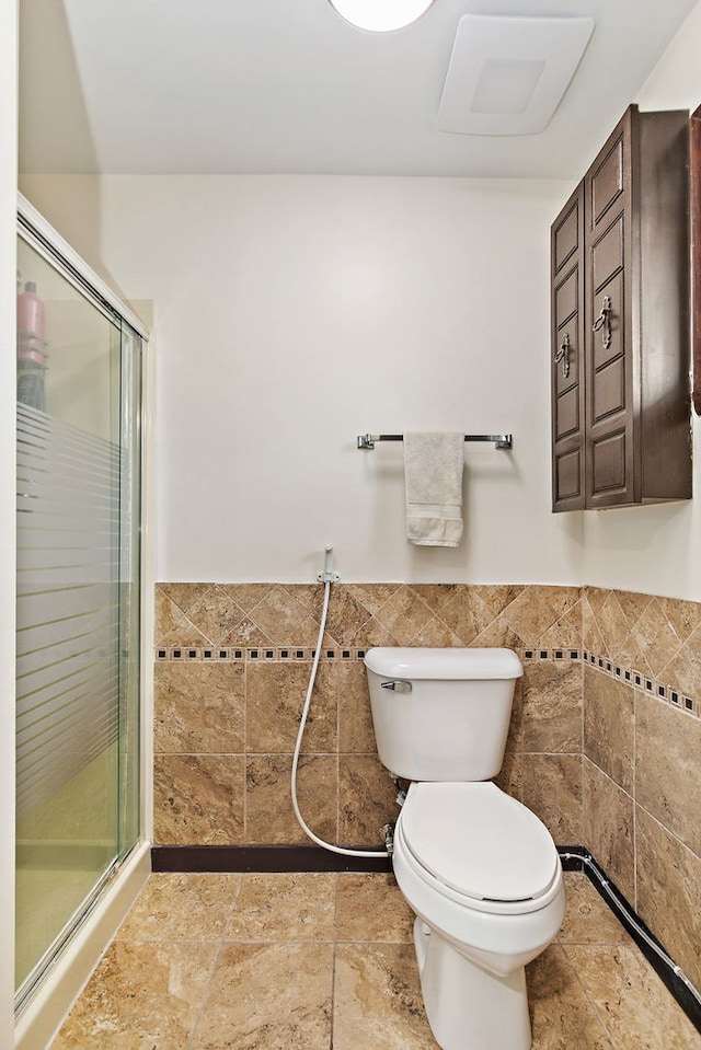 1083 Groton Ct, Schaumburg, IL 60193 - bathroom with tile walls, a shower stall, toilet, and wainscoting
