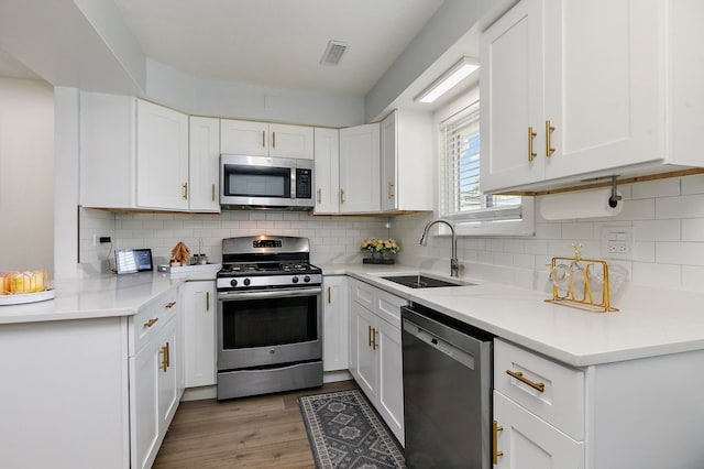 1083 Groton Ct, Schaumburg, IL 60193 - kitchen featuring appliances with stainless steel finishes, a sink, white cabinets, and wood finished floors