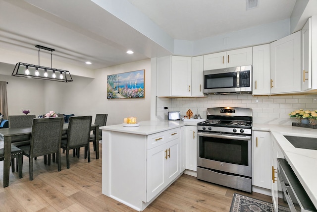 1083 Groton Ct, Schaumburg, IL 60193 - kitchen with stainless steel appliances, a peninsula, recessed lighting, light wood-style floors, and white cabinetry