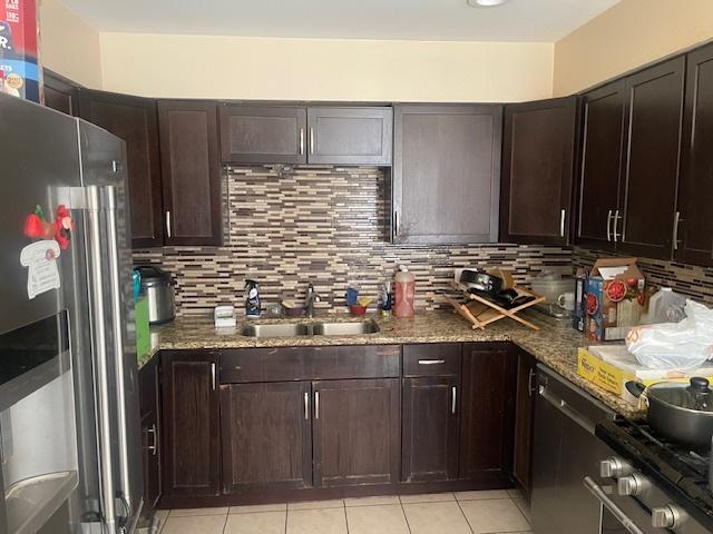 1713 W Thome Ave, Chicago, IL 60660 - kitchen with stainless steel appliances, a sink, stone countertops, and backsplash