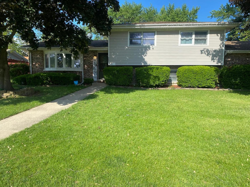 1161 Comet Dr, Aurora, IL 60505 - tri-level home featuring a front lawn and brick siding