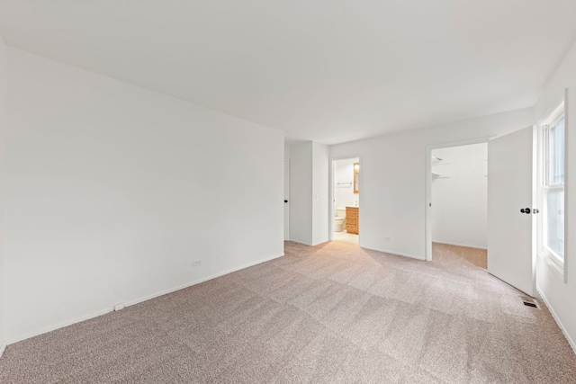 2S644 Devonshire Ln, Glen Ellyn, IL 60137 - unfurnished bedroom featuring light carpet, a walk in closet, ensuite bath, baseboards, and a closet