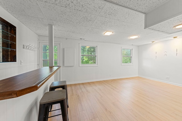 2S644 Devonshire Ln, Glen Ellyn, IL 60137 - unfurnished dining area featuring a paneled ceiling, light wood-style flooring, baseboards, and a bar