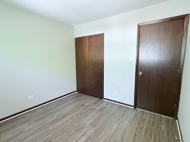 19828 Monterey Ave, Lynwood, IL 60411 - unfurnished bedroom with light wood finished floors, baseboards, and a closet