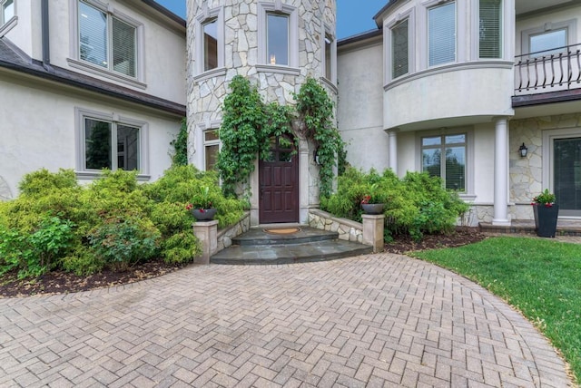 22W305 Broker Rd, Medinah, IL 60157 - view of exterior entry with stone siding, stucco siding, and a balcony