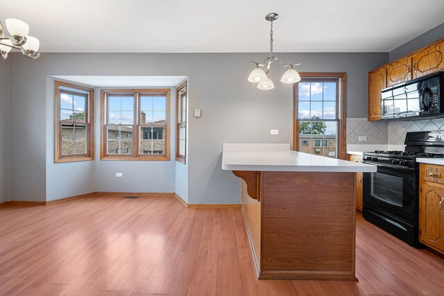 5343 S Long Ave Unit 5, Chicago, IL 60638 - kitchen with black appliances, a chandelier, light wood-type flooring, and brown cabinetry