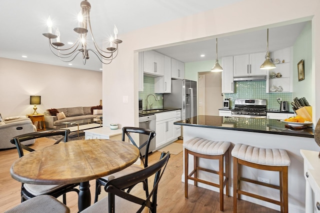 54 Brookston Dr Unit A1, Schaumburg, IL 60193 - kitchen with appliances with stainless steel finishes, a sink, dark countertops, tasteful backsplash, and under cabinet range hood