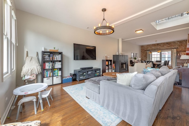 2044 W Roscoe St Unit 2S, Chicago, IL 60618 - living area with wood finished floors, a skylight, a chandelier, a fireplace, and brick wall