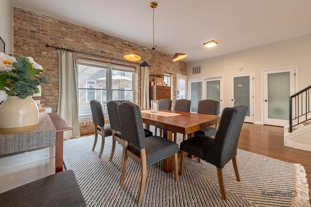 2044 W Roscoe St Unit 2S, Chicago, IL 60618 - dining space featuring brick wall, wood finished floors, stairway, and baseboards