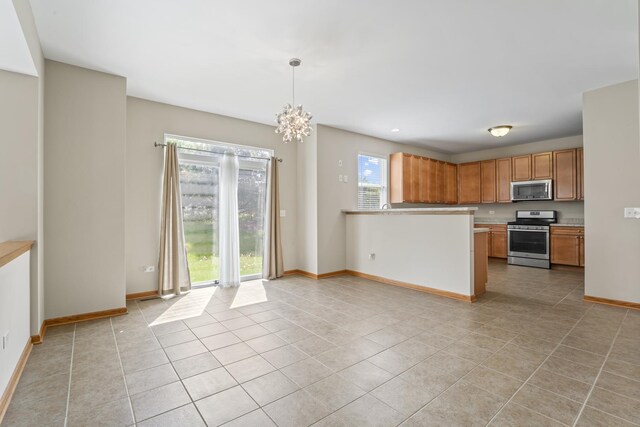 3816 Stockton Dr, Joliet, IL 60436 - kitchen with stainless steel appliances, light tile patterned floors, baseboards, brown cabinetry, and a chandelier