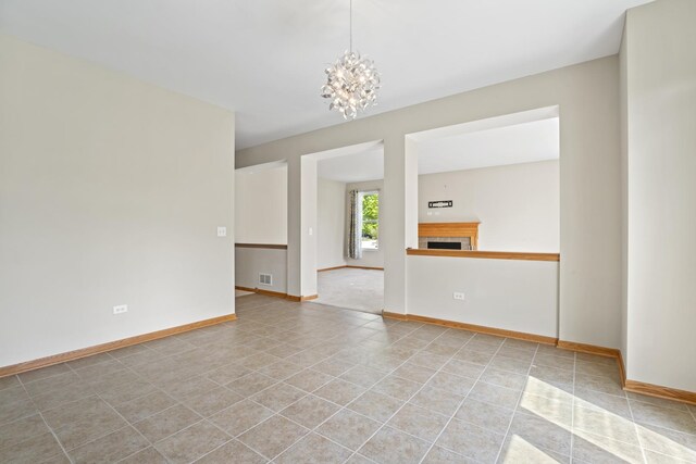 3816 Stockton Dr, Joliet, IL 60436 - unfurnished room with a chandelier, a fireplace, baseboards, and light tile patterned floors