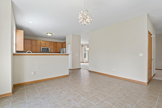3816 Stockton Dr, Joliet, IL 60436 - unfurnished living room with a chandelier and baseboards