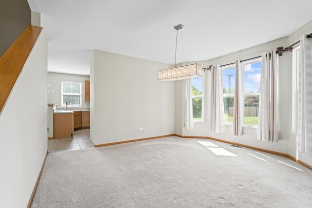 3816 Stockton Dr, Joliet, IL 60436 - spare room with light carpet, baseboards, a chandelier, and a sink