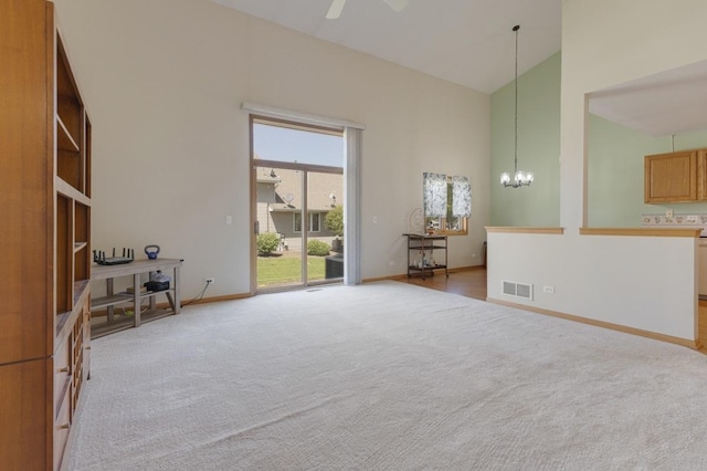816 Adam Ln, Hampshire, IL 60140 - unfurnished living room featuring light carpet, high vaulted ceiling, a chandelier, ceiling fan, and baseboards