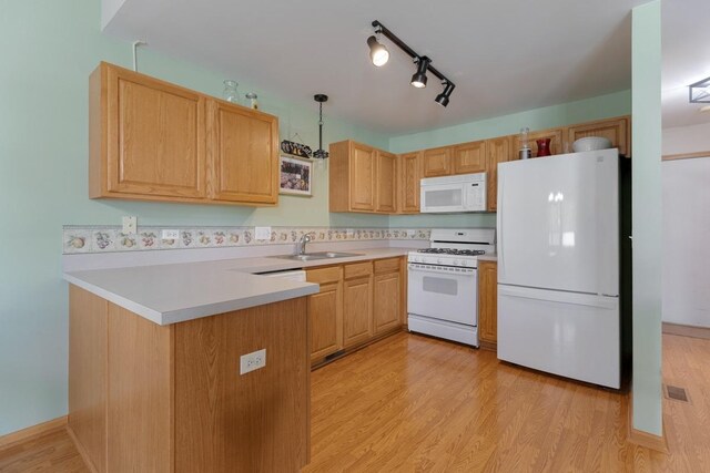 816 Adam Ln, Hampshire, IL 60140 - kitchen with white appliances, a peninsula, a sink, light wood-style floors, and light countertops