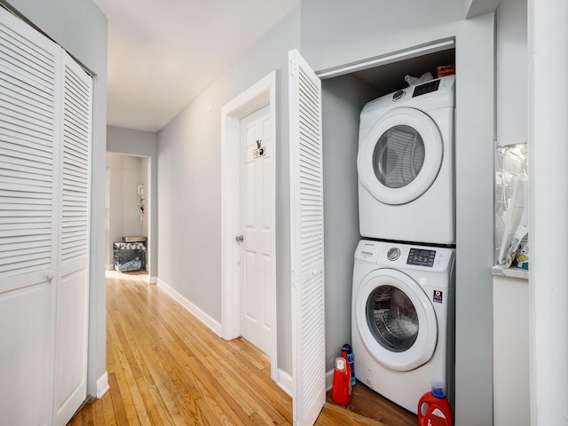 6111 S Eberhart Ave, Chicago, IL 60637 - washroom featuring stacked washing machine and dryer, light wood-style floors, and baseboards